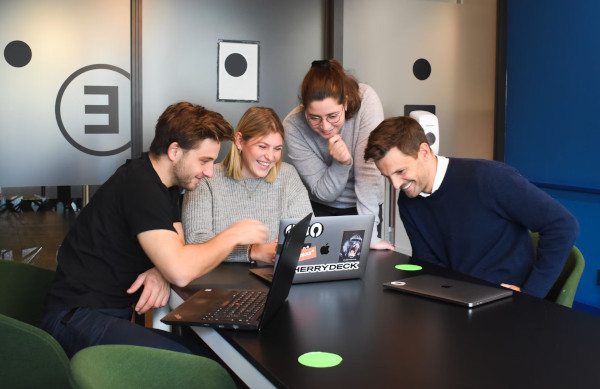 Vierk&ouml;pfiges gut gelauntes Team in Konferenzraum